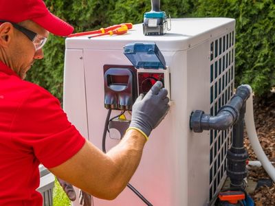 Technicien installant une pompe à chaleur piscine