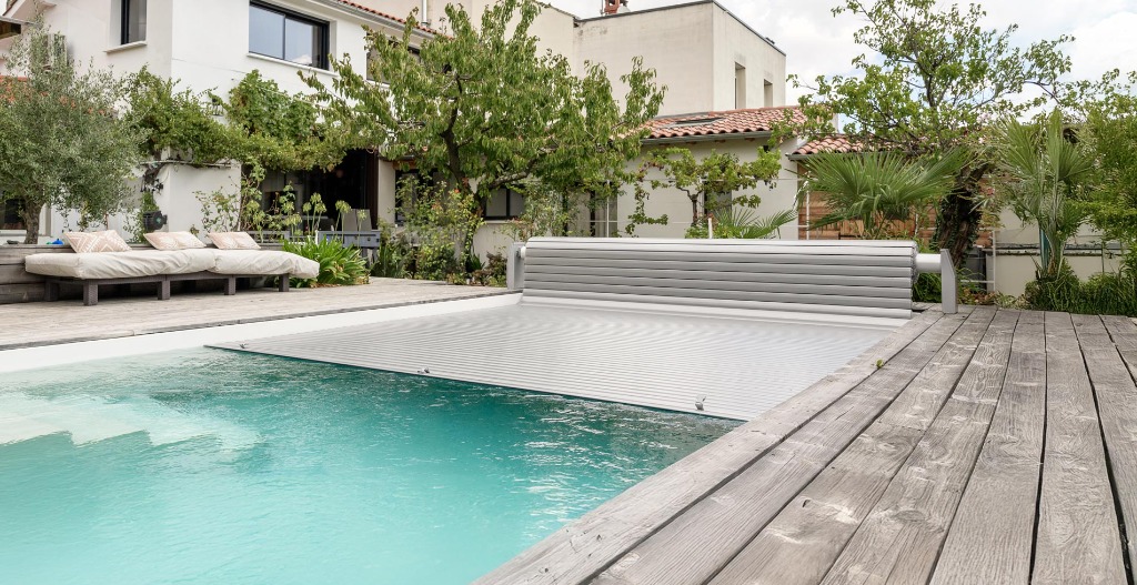 Volet roulant hors-sol piscine gris sur terrasse bois
